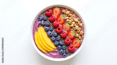 A vibrant and healthy bowl of fruit and granola on a clean white background
