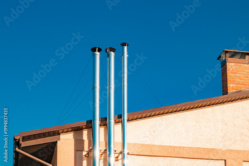 metal chimneys on the roof of the house