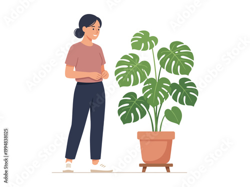 Woman standing next to a large potted monstera deliciosa houseplant with big green leaves in a terracotta pot on a stand