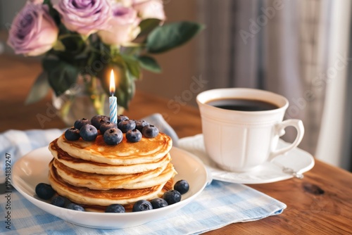 Delicious Pancakes With Blueberries and Coffee on a Table With Flowers Nearby