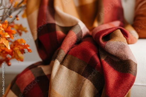 Cozy Blanket With Warm Colors on a Sofa in a Living Room With Autumn Decorations
