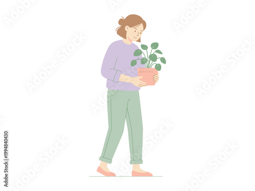 A young woman with her hair in a bun is holding a potted plant and walking gently with a serene expression