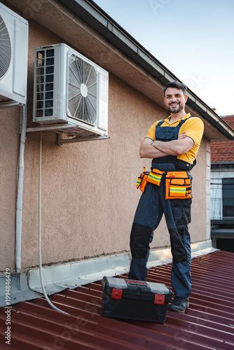 Canvas Print Hvac technician posing with arms crossed after installing an air conditioner on