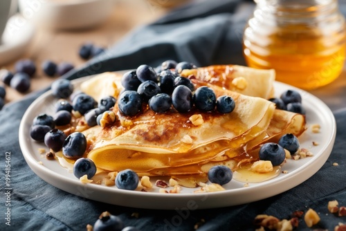 Pancakes With Blueberries and Honey Served on a White Plate in a Bright Kitch...