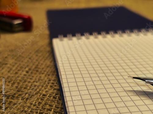 A fountain pen on an open notebook. The elegant writing instrument rests on a blank sheet of paper. Concept for business correspondence or education.