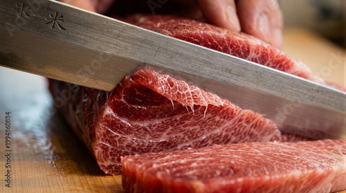 Chef slicing raw wagyu beef with sharp Japanese knife