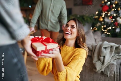 Woman Smiles While Receiving a Gift During a Holiday Gathering With Decoratio...