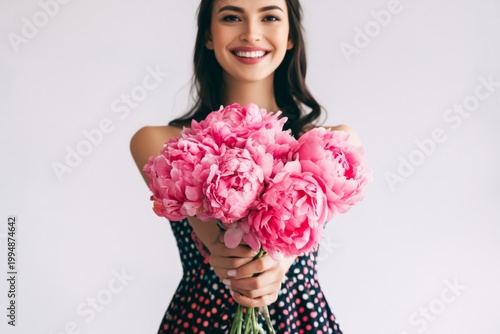 Woman Holding Bouquet of Pink Peonies in Studio Setting During the Daytime