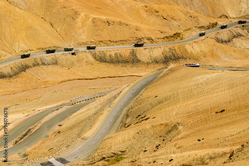 Indian Military trucks passing through Zigzag road, famously known as jilabi road at old route of Leh to Srinagar Highway, Ladakh, Jammu and Kashmir, India. Scenic and popular route through mountains.