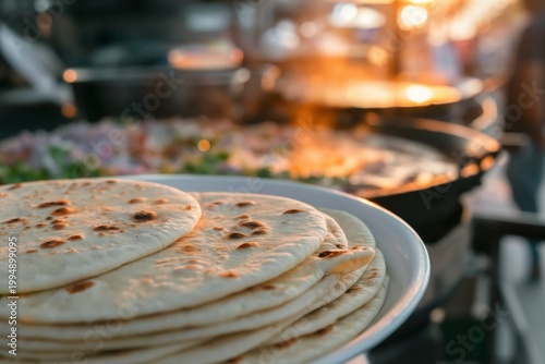 Freshly Made Naan Bread on Plate With Various Dishes in Background During Bus...
