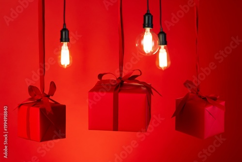 Hanging Gifts and Light Bulbs in Red Background During Festive Season