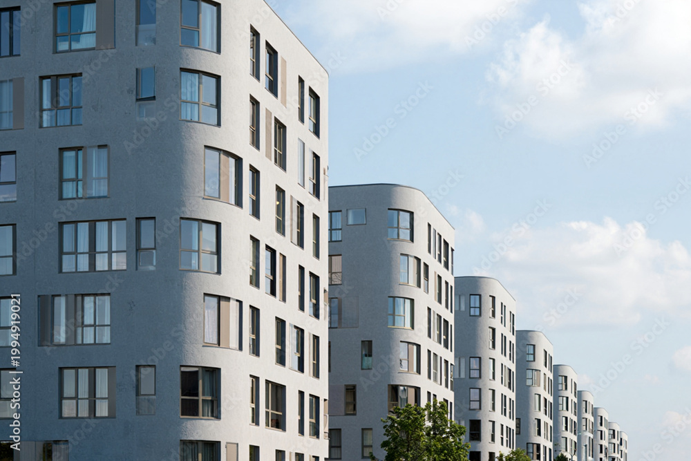 Fototapeta premium Row of modern apartment buildings with curved facades, blue sky