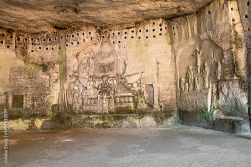 Ancient monumental stone carvings inside a medieval troglodyte cave, including the Last Judgment in Brantome, France