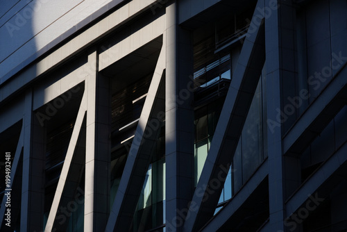 Angular structural beams of modern building in sunlight and shadow