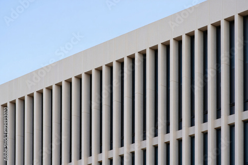 Close up of building facade with vertical elements and blue sky