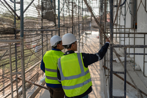 Construction workers inspecting scaffolding installation construction site image urban environment close-up view safety compliance