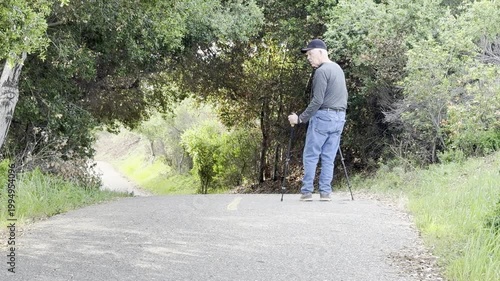 Senior man with hiking poles checks his surroundings