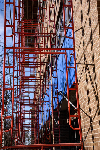 Steel scaffolding erected adjacent to multi story building for window cleaning.