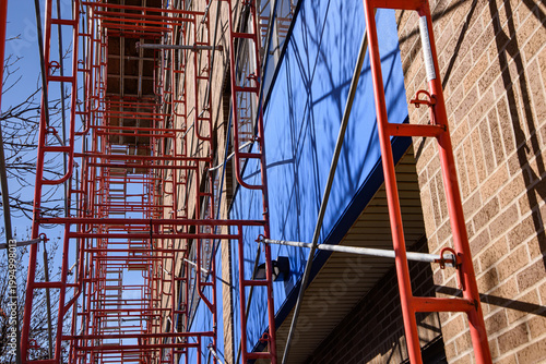 Steel scaffolding erected adjacent to multi story building for window cleaning.