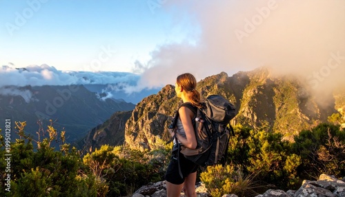 An Hiker with backpack close up dramatic mountain landscape with mist in the valley