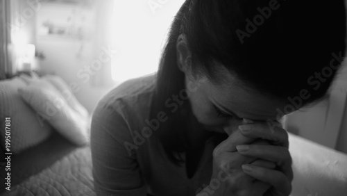 Canvastavla Close-up of woman sitting with head bowed and hands clasped, expressing emotiona