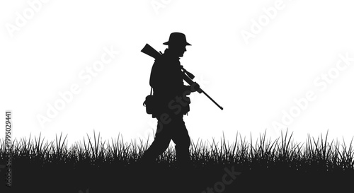 Silhouette of a hunter walking through tall grass with a rifle