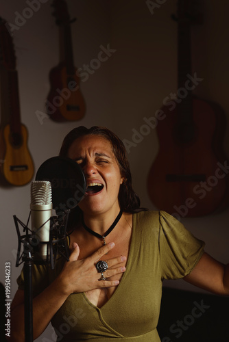 Woman singing and recording vocals in home studio