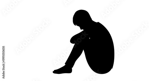 Silhouette of a person sitting with knees drawn up appearing despondent