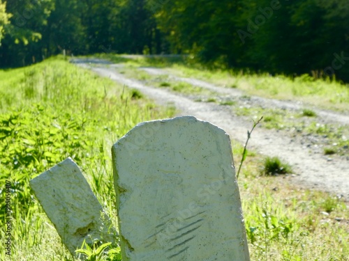 Weathered white milestones along a lonely dirt road in the countryside