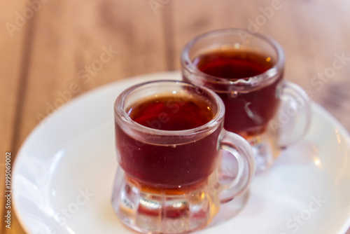 A photo of two glasses of Pacharan, typical sloe flavored Spanish liquor