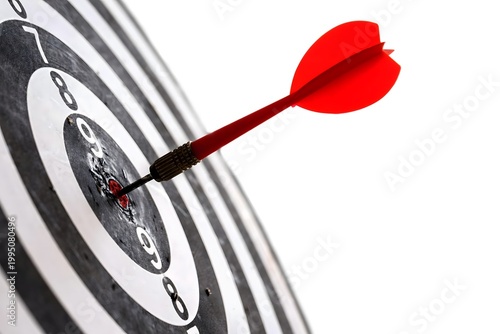 Dart hitting bullseye on target board close-up success concept