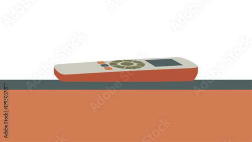 A cream-colored remote control with green and orange buttons rests on a dark gray surface