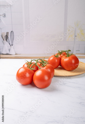 Tomatoes, beautiful red tomatoes in rustic bowls on a very bright kitchen counter, selective focus.