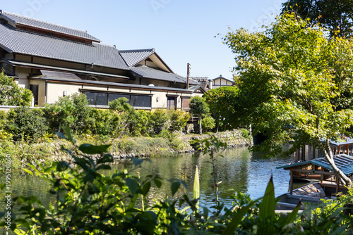 Traditional sightseeing boat sailing on river in Kyoto near Arashiyama and Togetsukyo bridge in Kyoto, Japan 