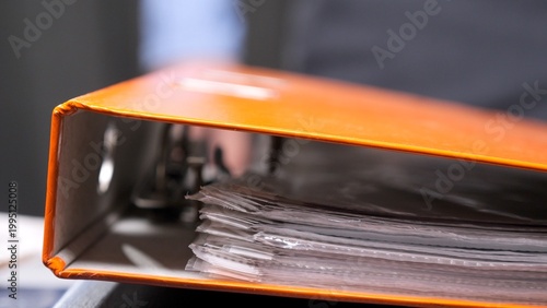 Εκτύπωση καμβά Orange ring binder holding many clear plastic sleeves filled with important pape