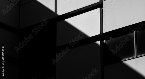 Abstract black and white architectural detail of a modern building facade with strong geometric shapes and dramatic shadows