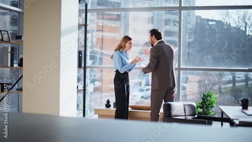 Business partners quarrelling documents mistake standing office panoramic window
