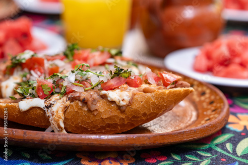 Bild auf Leinwand desayuno mexicano, en mesa con mantel, jugos y fruta, juego, frijoles y pan