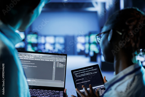 Photography IT developers building firewall systems in server room housing advanced infrastructure