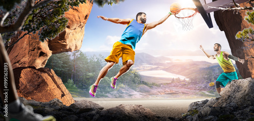 Basketball. Two basketball players practice on a basketball court in the wilderness. A beautiful landscape is in the background.