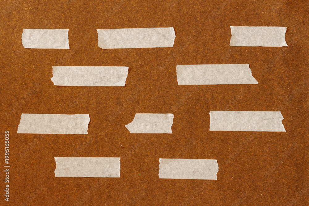 Fototapeta premium Masking tape strips arranged on textured surface, empty space. Natural background for design template, layout, branding usage, surface detail, copy space