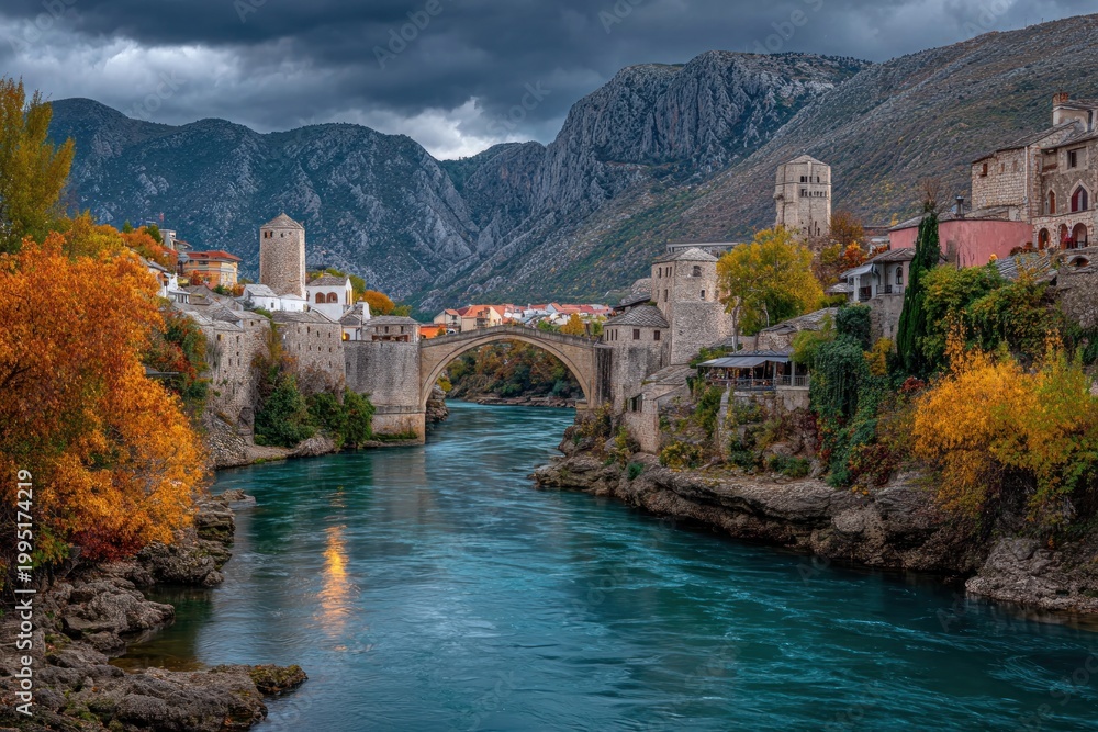 Fototapeta premium Medieval Bridge Over Turquoise River in Autumnal Mountain Town