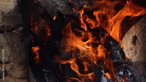 Burning wood boards in the oven close up. Burning firewood and smoke in the handmade oven. Flame in a cozy fireplace at outdoor, keep warm. Hot background.
