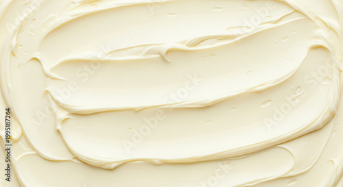 A close-up of smooth, creamy white frosting with soft swirls and gentle ridges.