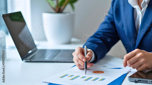 Business Acumen: An individual in a professional setting meticulously reviews financial charts and data on a desk, poised to make strategic business decisions.