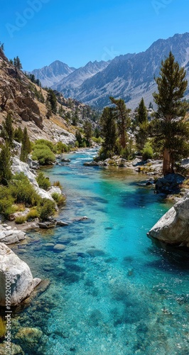 Serene mountain river winds through a valley, surrounded by rocky peaks and pine trees