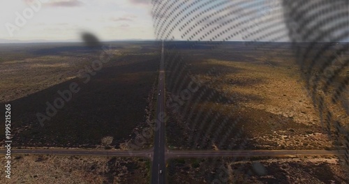 Running straight two-lane highway cutting through arid plain to horizon, showing cars, mesh overlay