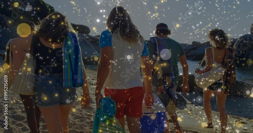 Walking five adults wearing bucket hat, carrying towel and coolers toward water on beach