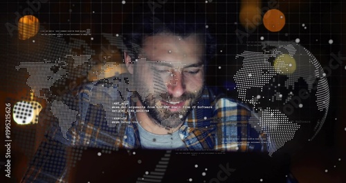 Typing bearded developer wearing plaid shirt, leaning over laptop at home, showing globe overlays