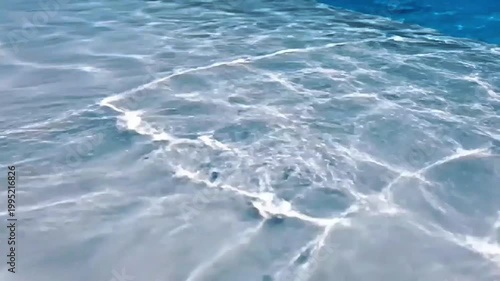 Gentle Ripples on a Clear Blue Pool Surface Reflecting Sunlight Creates Beautiful Abstract Patterns